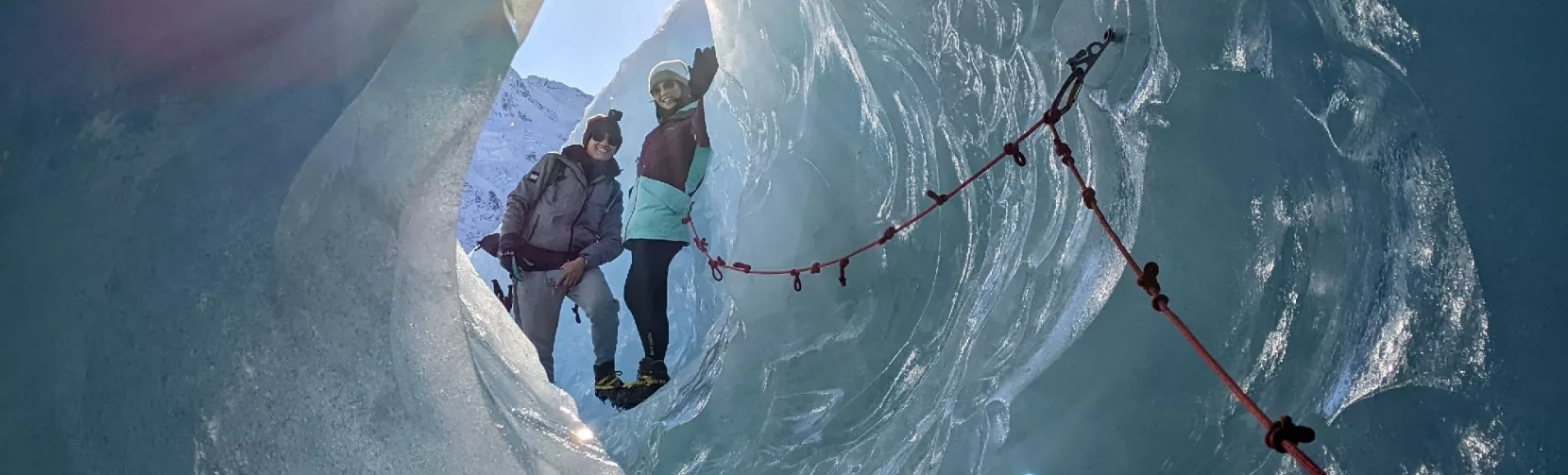 Sunlight streaming through a glacial ice cave on Mount Cook heli hike