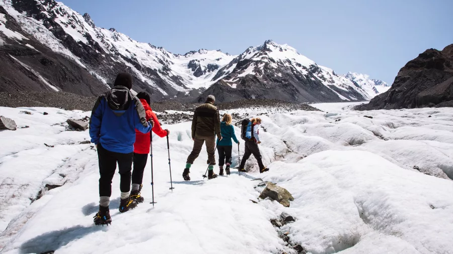 Group of hikers making their way across the Tasman Glacier near Aoraki Mount Cook
