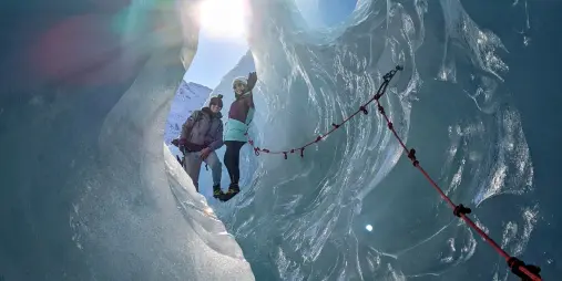 Sunlight streaming through a glacial ice cave on Mount Cook heli hike