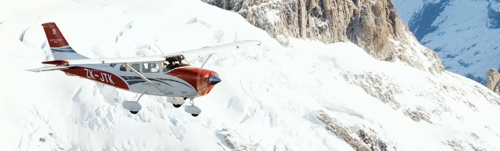 Glenorchy Air scenic flight soaring above snow-covered peaks in the Southern Alps