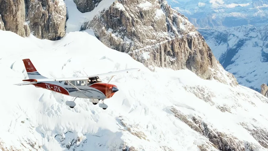 Glenorchy Air scenic flight soaring above snow-covered peaks in the Southern Alps