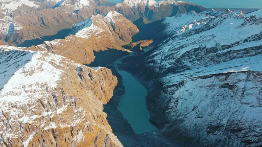 Scenic aerial view of a glacier-carved valley and lake in New Zealand's Southern Alps