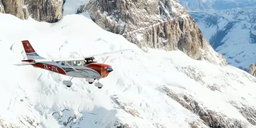 Glenorchy Air scenic flight soaring above snow-covered peaks in the Southern Alps