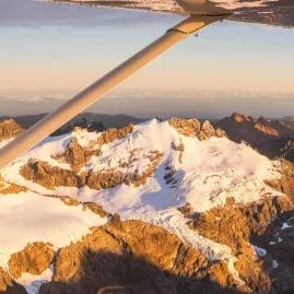 Snow-dusted peaks of Mt Aspiring National Park glowing in sunrise light