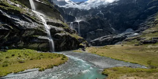Turquoise glacial stream winding through Earnslaw Burn valley