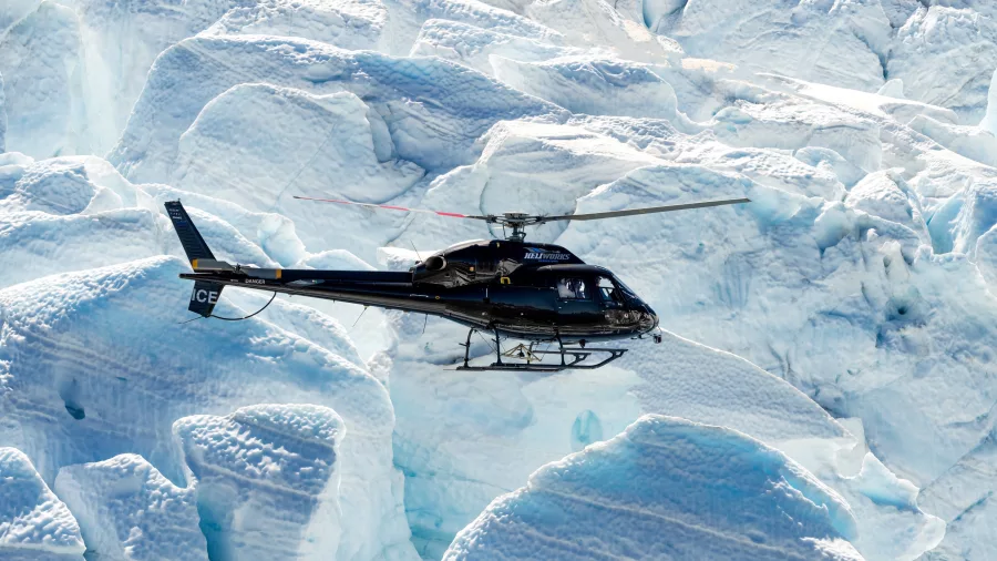 Heli Glenorchy helicopter flying over deep crevasses on Tutoko Glacier