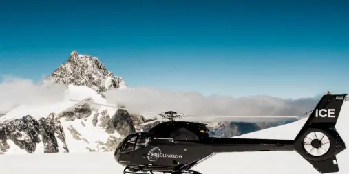 Black helicopter parked on a snow-covered glacier near Glenorchy.