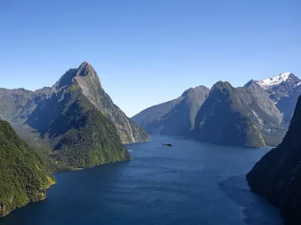 Helicopter flying above Milford Sound with Mitre Peak in view