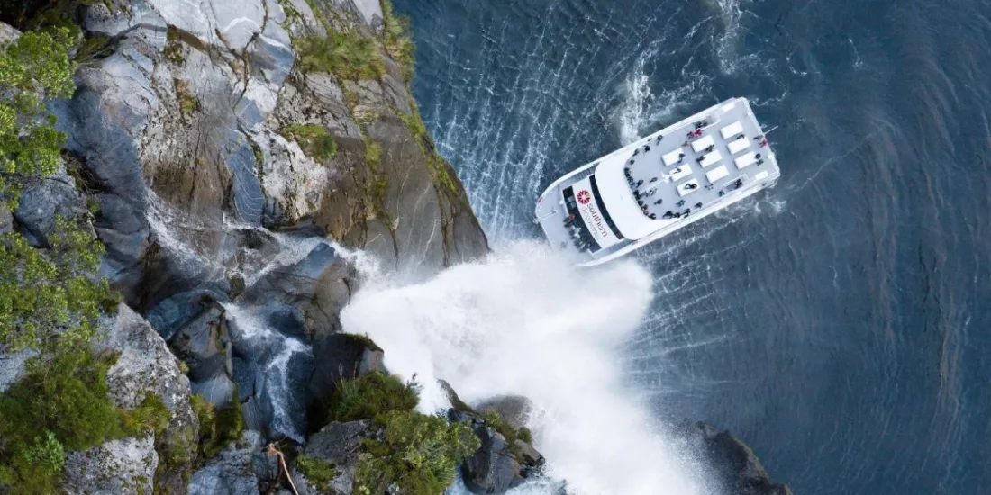 Southern Discoveries cruise boat beneath Stirling Falls in Milford Sound
