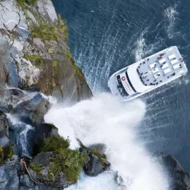 Southern Discoveries cruise boat beneath Stirling Falls in Milford Sound