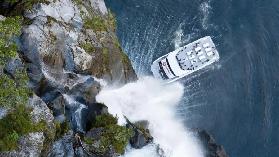 Southern Discoveries cruise boat beneath Stirling Falls in Milford Sound