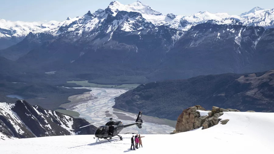Helicopter landing on snow with Rees and Dart River valleys in the distance