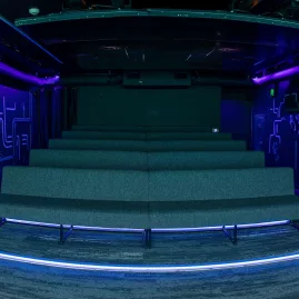 Interior of Time Tripper’s immersive theatre with LED lighting and bench seating