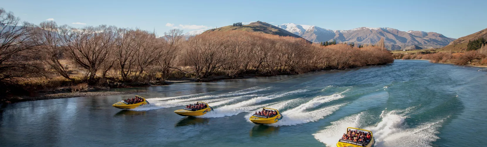 Four KJet boats racing side-by-side down the Kawarau River