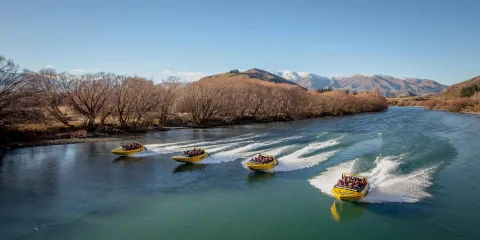 Four KJet boats racing side-by-side down the Kawarau River