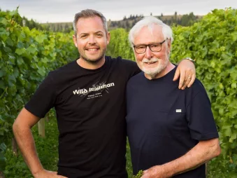 Alan Brady and family member standing in vineyard for Wild Irishman Wines