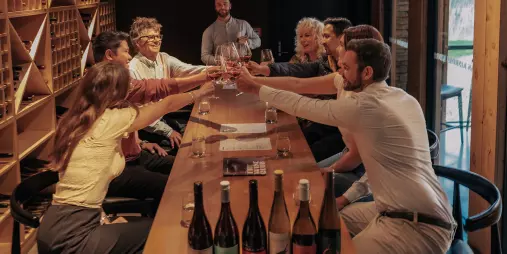 Group of guests raising glasses during a wine tasting at Kinross