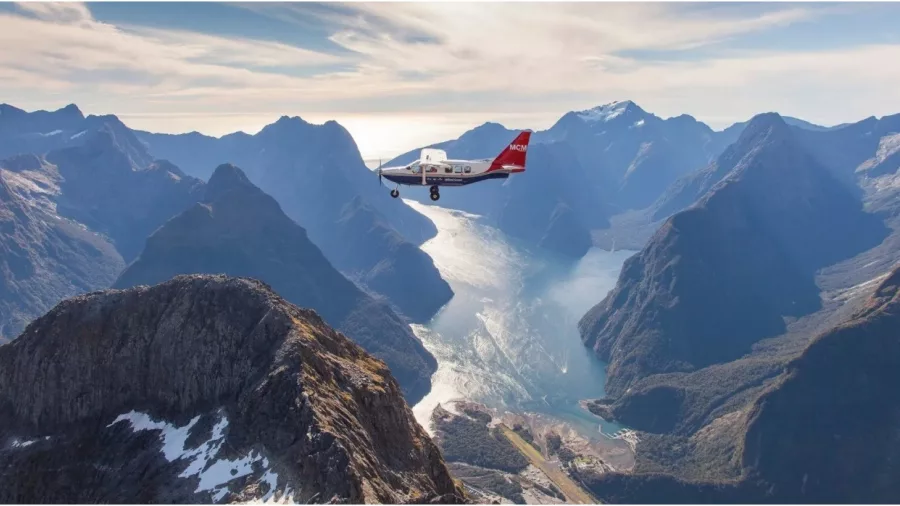 Plane flying above Milford Sound with dramatic fiord landscape below