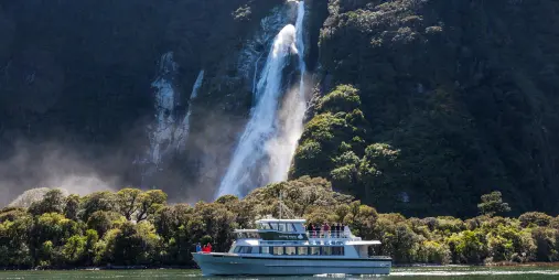 Mitre Peak Cruises boat passing Bowen Falls in Milford Sound