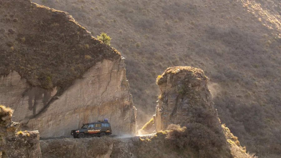 4WD vehicle navigating narrow cliffside road in Skippers Canyon