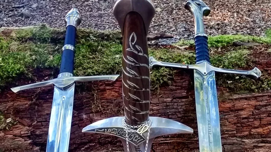 Replica swords from The Lord of the Rings on display in a forest setting