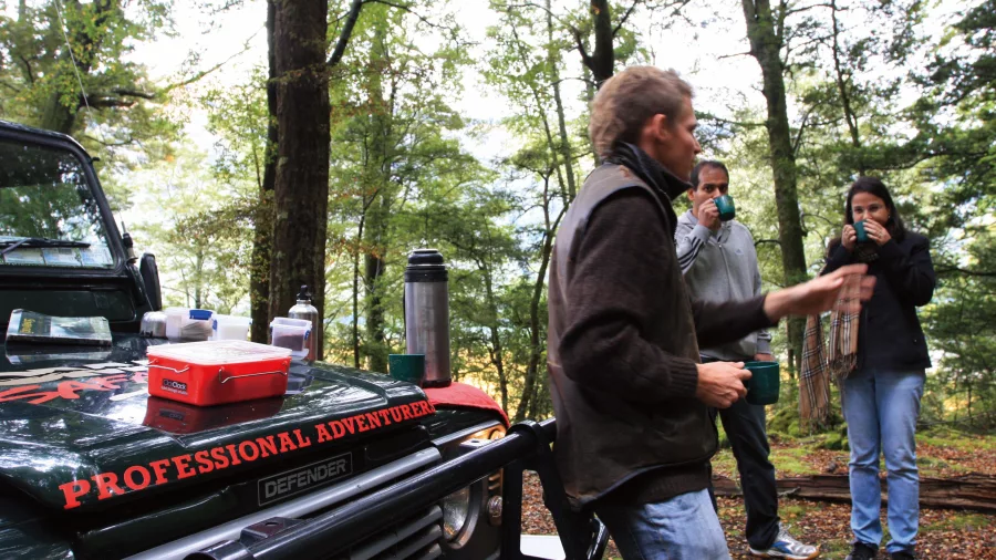 Guide serving morning tea beside 4WD vehicle in Glenorchy forest