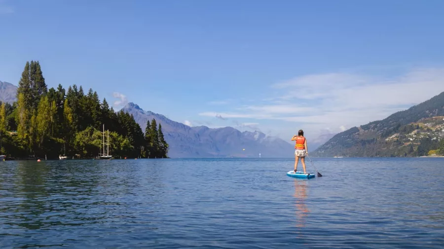 Paddleboarder on Lake Wakatipu looking towards Queenstown’s Remarkables mountain range