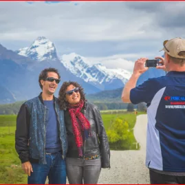 Pure Glenorchy guide taking a photo of a couple with snowy peaks in the background