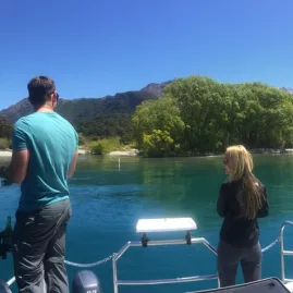 Man and woman fishing near the shore on a boat in Lake Wakatipu