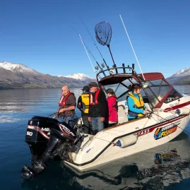 Group of people fishing from a Queenstown Fishing boat on Lake Wakatipu