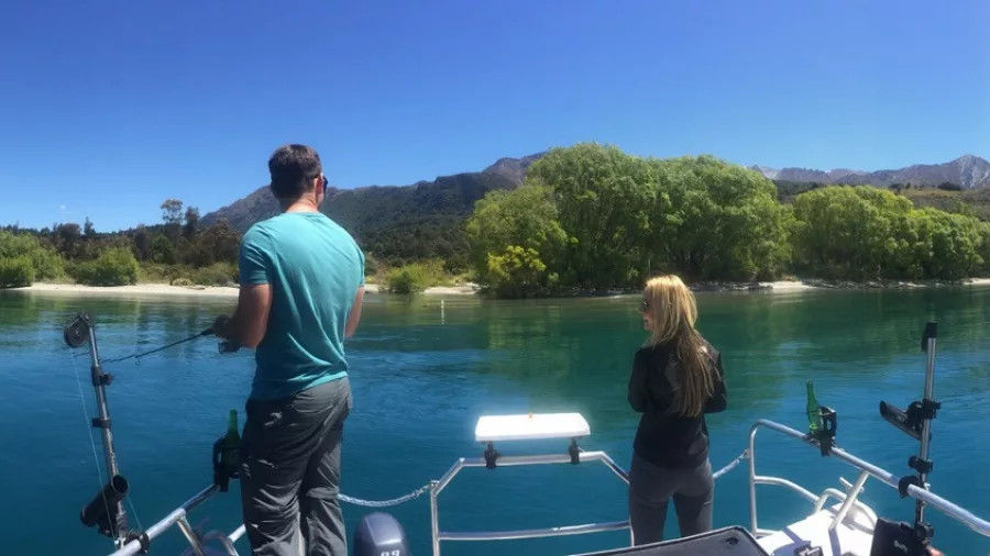 Man and woman fishing near the shore on a boat in Lake Wakatipu