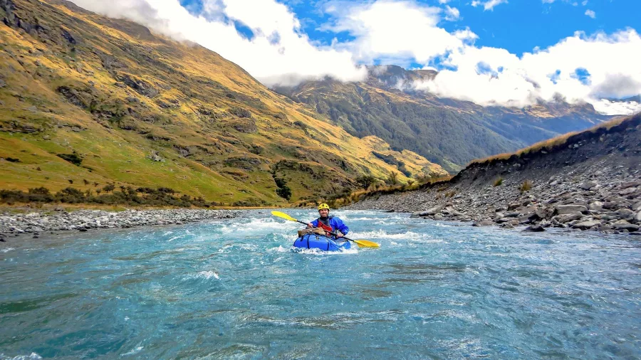 Packrafter paddling down a glacial river in Mount Aspiring National Park near Wanaka