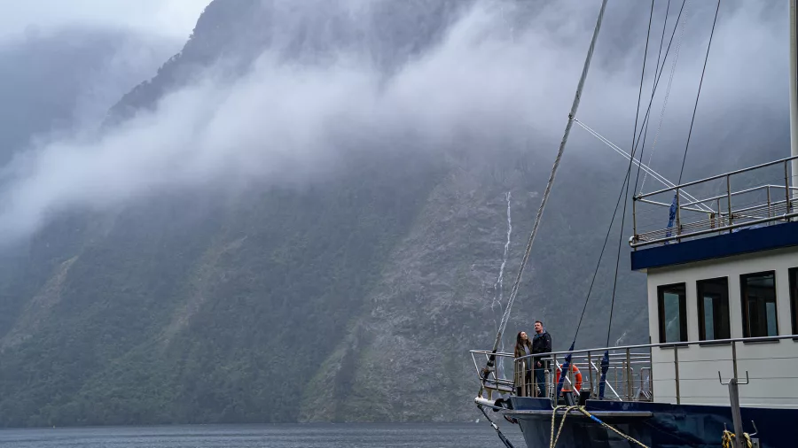 Passengers on deck of the Fiordland Navigator enjoying views of misty Doubtful Sound
