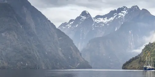Fiordland Navigator cruising past snowy mountains in Doubtful Sound