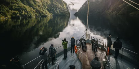 People viewing the scenery from the deck of the Fiordland Navigator on Doubtful Sound