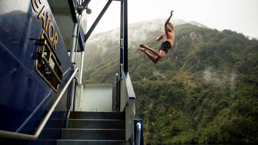 Man jumping off the Fiordland Navigator into the water below