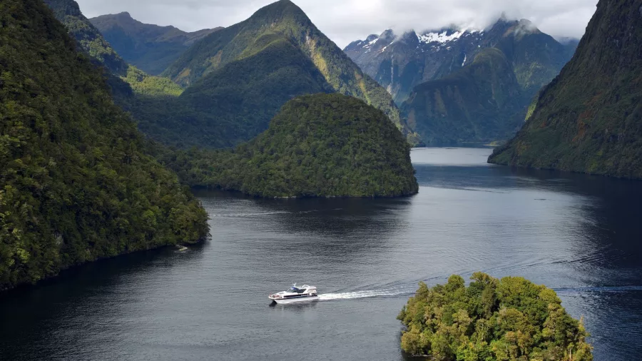 Aerial view of the Patea Explorer cruising past small islands in Doubtful Sound’s vast fiord landscape
