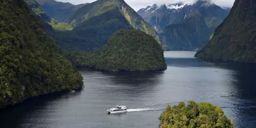Aerial view of the Patea Explorer cruising past small islands in Doubtful Sound’s vast fiord landscape