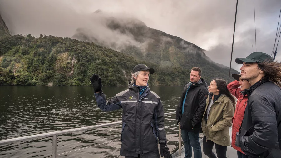 Nature guide leading a group of travellers on a cruise through Doubtful Sound