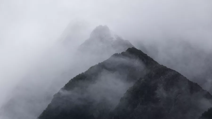 Mountain ridges in Doubtful Sound disappearing into low-hanging mist and fog