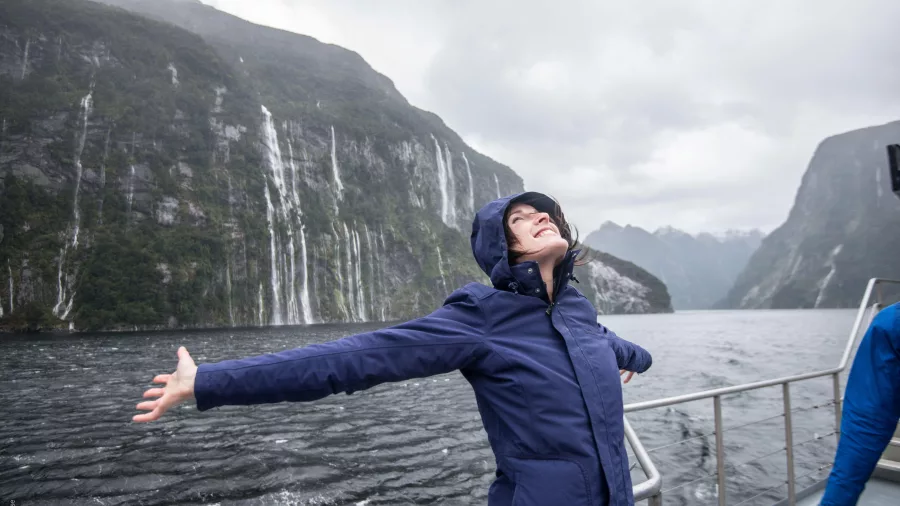 Woman smiling in the rain on a cruise near waterfalls in Doubtful Sound, Fiordland