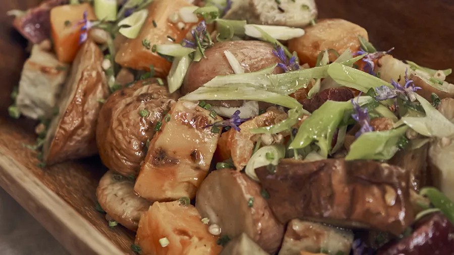 Rustic bowl of roasted vegetables garnished with herbs at Walter Peak BBQ