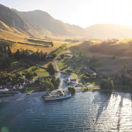 Aerial view of TSS Earnslaw arriving at Walter Peak Station in golden light