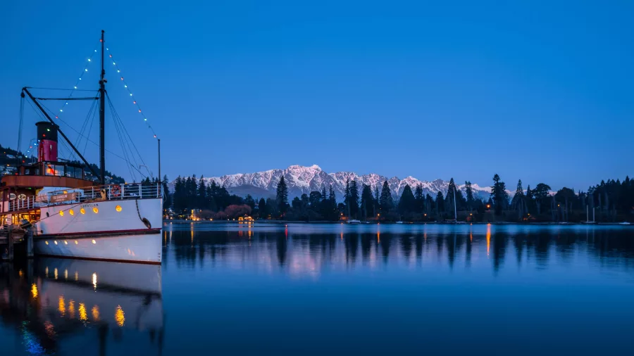 TSS Earnslaw docked at Queenstown with the Remarkables mountain range at dusk