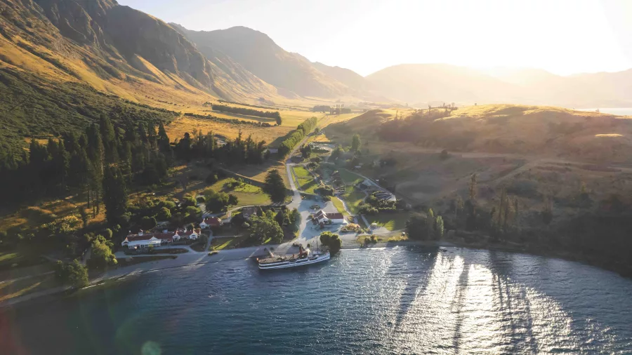 Aerial view of TSS Earnslaw arriving at Walter Peak Station in golden light