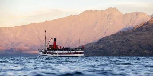 TSS Earnslaw steamboat cruising on Lake Whakatipu with mountains beyond