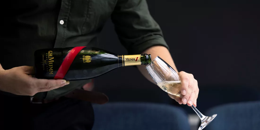 Glass of G.H. Mumm champagne being poured on board the Milford Sound Business Class Cruise