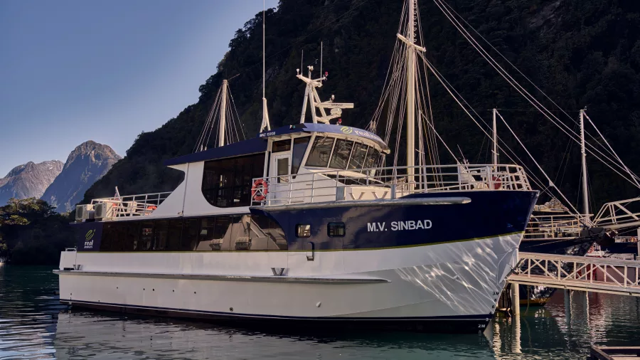 MV Sinbad docked in Milford Sound with mountains in the background