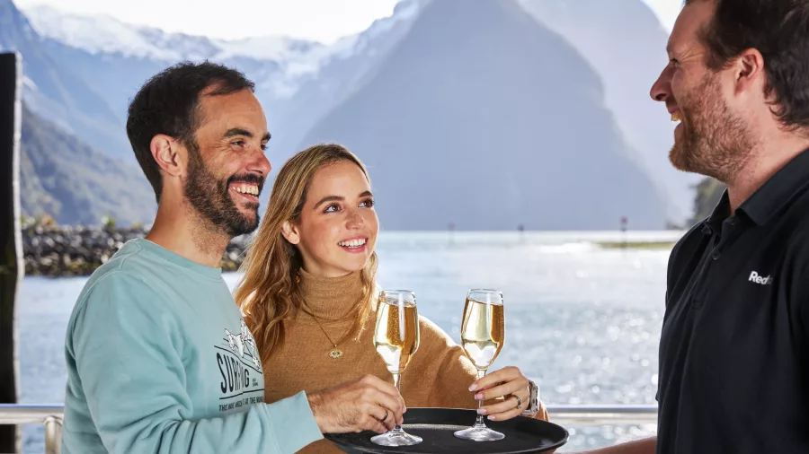 Couple enjoying champagne on board a Milford Sound scenic cruise