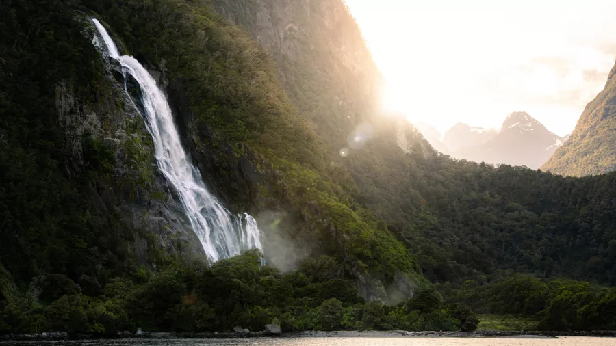 Stirling Falls cascading down cliffs at sunset in Milford Sound